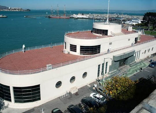 The Aquatic Park Bathhouse, which is shaped like a ship, overlooks the Aquatic Park harbor