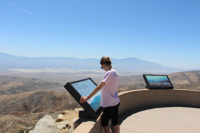 A visitor reads a wayside educational sign at Keys View