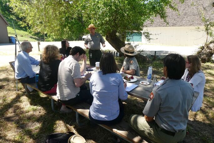A group of National Park Service staff holds a planning meeting at the picnic area