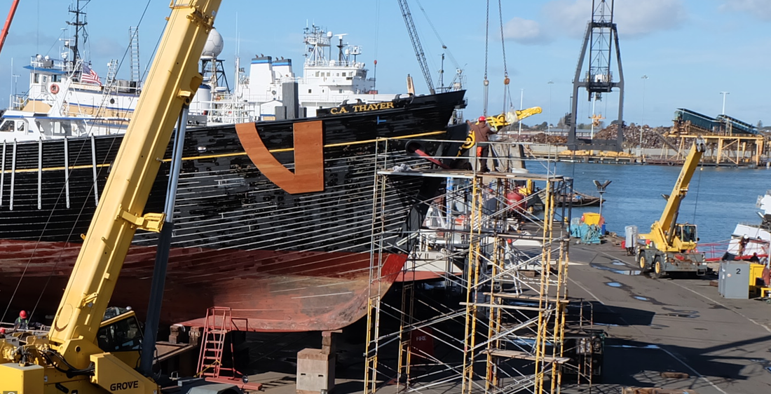 Scaffolding and cranes stand next to the hull of the C.A. Thayer