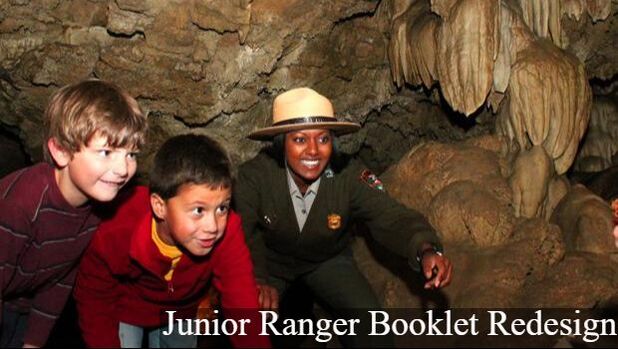 A ranger points at a stalactite in Oregon Caves while two children look