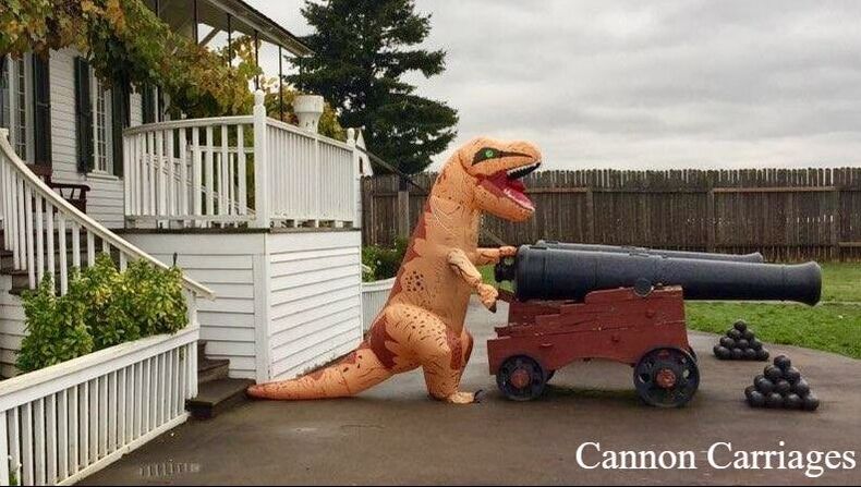 A T-Rex costume stands in front of a life-size historic cannon with a pile of cannon balls sitting adjacent. The words 