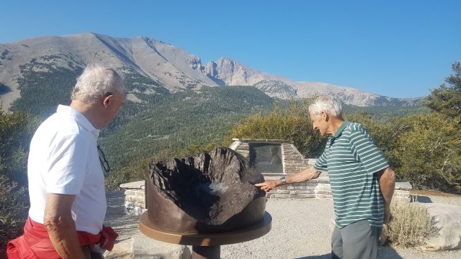Visitors look at and touch the bronze relief map, the spitting image of the Wheeler Peak Cirque in the background