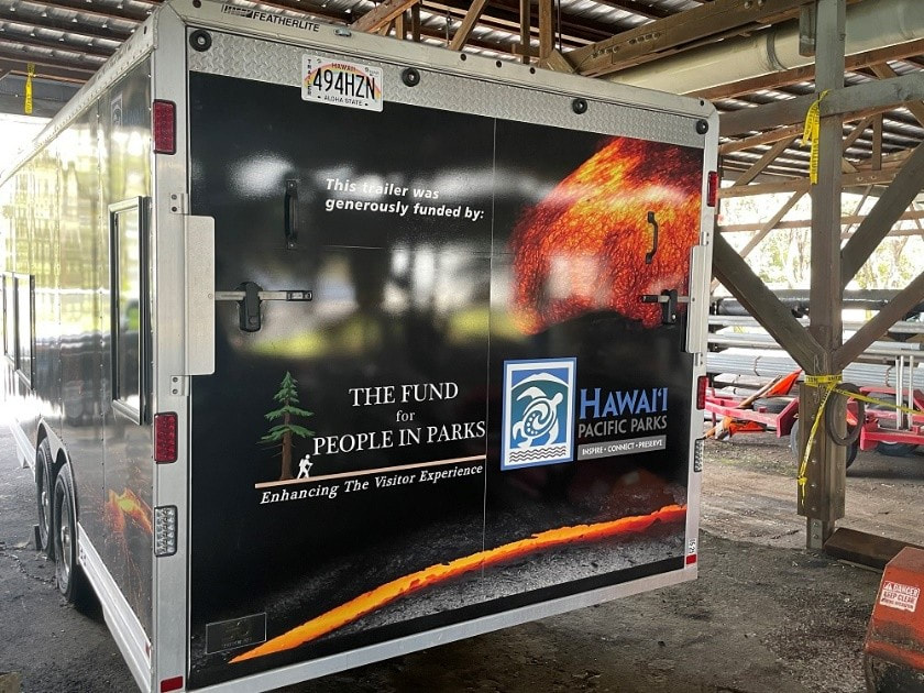 Back side of mobile visitor center with logos of The Fund for People in Parks and Hawai'i Pacific Parks Association, as well as depictions of lava