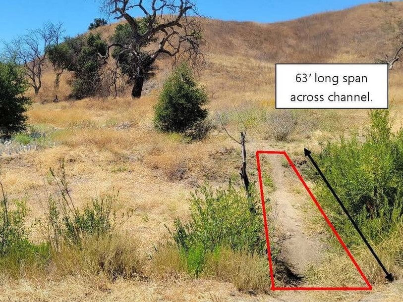 A red rectangle and arrow shows a 63' long span across a channel set against a yellow grassy hillside