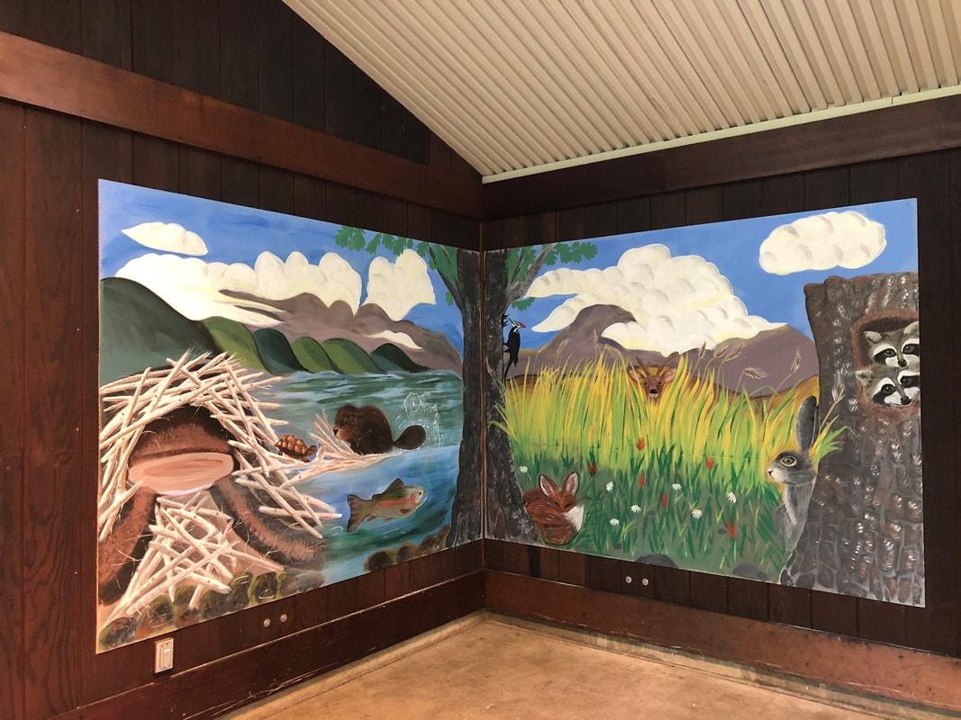 A mural of a waterway, wetland and trees adorns the walls of the picnic shelter