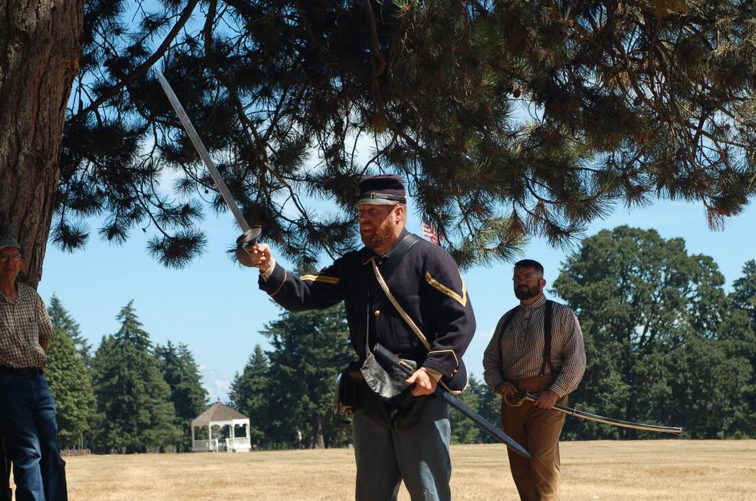 A ranger in a civil war uniform demonstrates the use of a cutlass (sword)