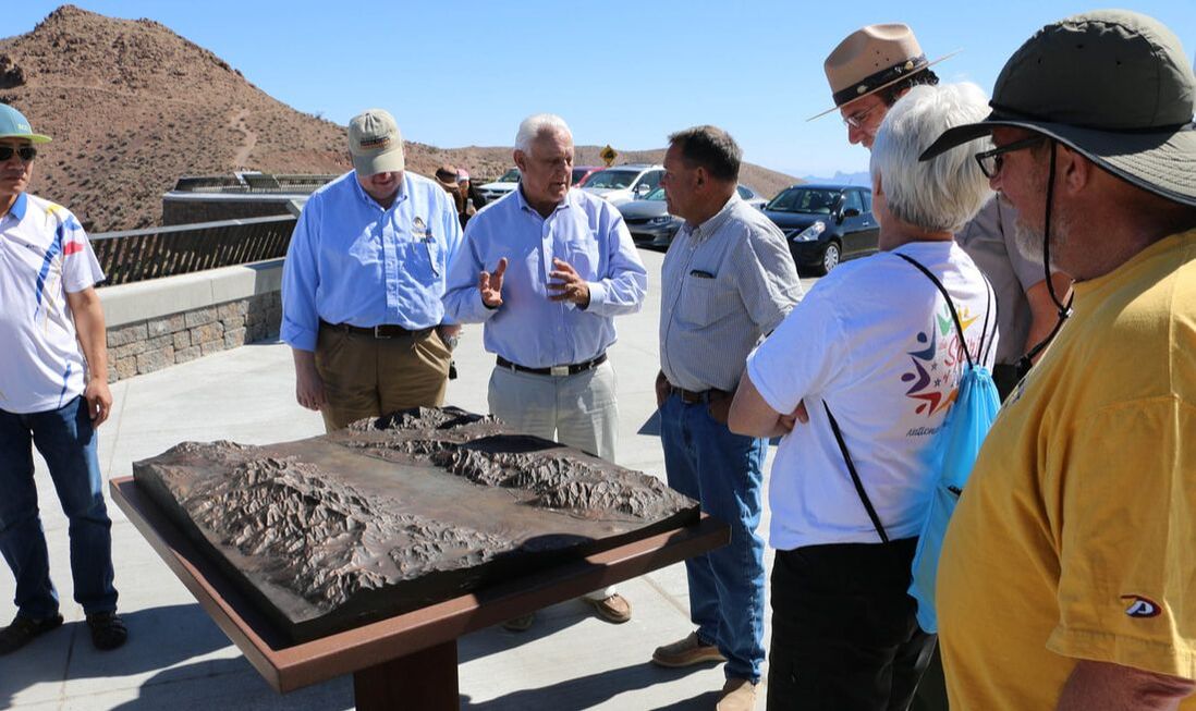 A group of people surrounds the newly-installed bronze relief map at Dantes View in Death Valley