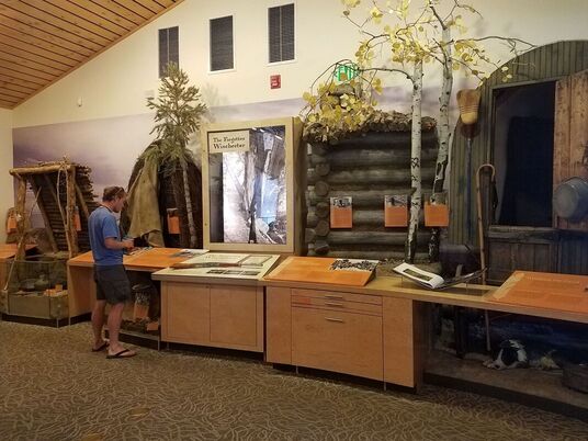 A visitor explores the pioneer history section of the Baker Visitor Center, including the Forgotten Winchester