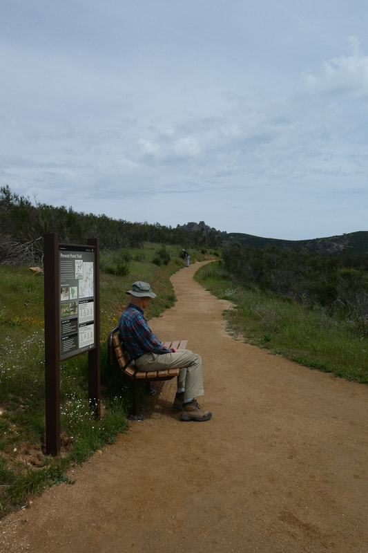 A visitor sits on a new bench on the Prewett Point Trail