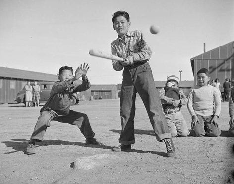 Black and white image of children playing baseball at Manzanar while incarcerated