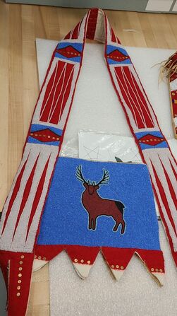 A horse martingale, beaded in red, white, and blue, featuring a large buck