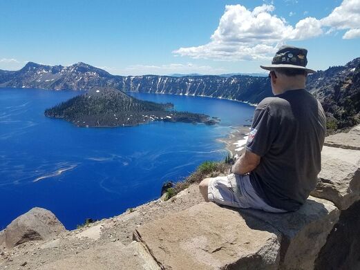 Visitor at North Junction overlook looking toward Wizard Island on Crater Lake