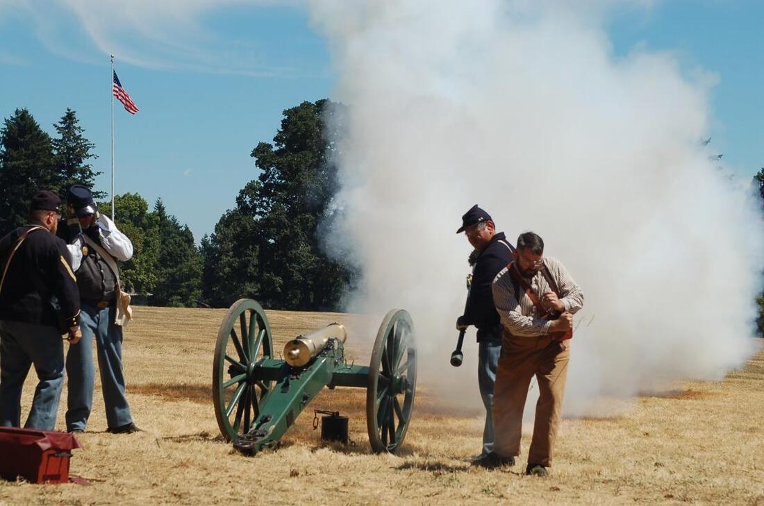 Volunteers in civil war uniforms shoot off a cannon